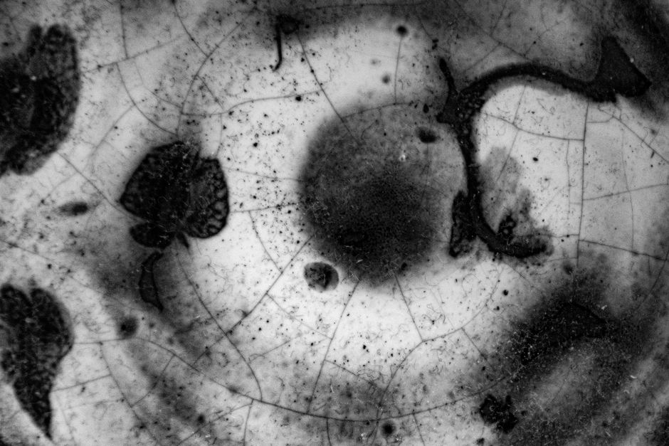 A detailed close-up of a cracked ceramic surface with abstract patterns and textures.